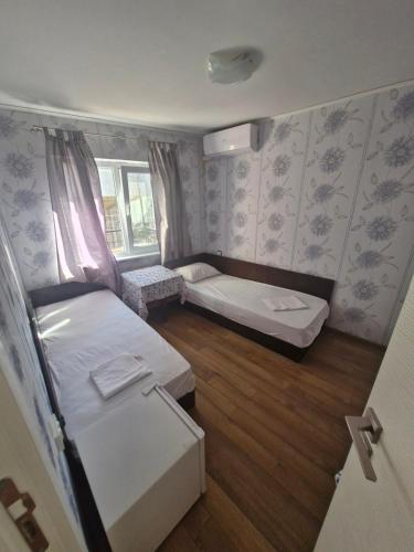 a small room with two beds and a window at Mihalkat Old Town in Sozopol