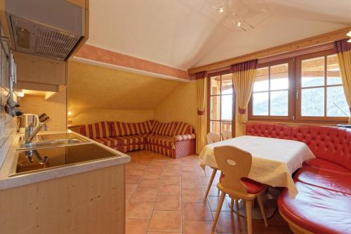 a kitchen and living room with a table and a couch at Bruneggerhof Weissenbach in Rio Bianco