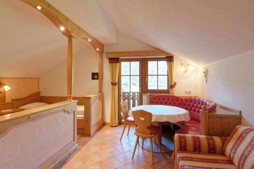 a living room with a table and a couch at Bruneggerhof Weissenbach in Rio Bianco