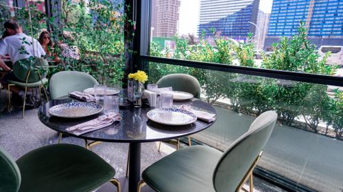 a table and chairs in a room with a window at Alliance Palace Seaside in Batumi