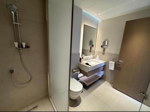 een badkamer met douche, toilet en wastafel bij Apartment at Vida Marina Marassi in El Alamein