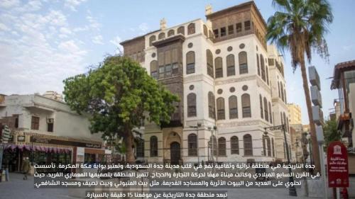 a large white building with a tree in front of it at نسمة كيان للشقق المخدومة in Jeddah