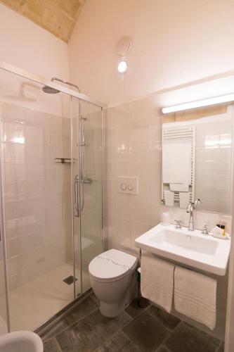 a bathroom with a toilet and a sink and a shower at Il Vialetto Nei Sassi in Matera
