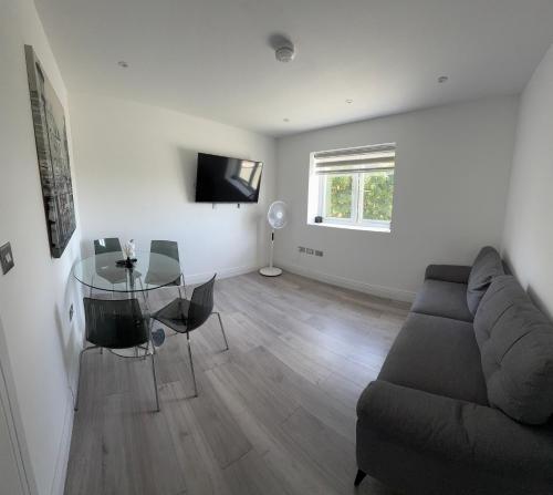 a living room with a couch and a glass table at QB Stylish 2 Bedroom Apartment - Smart TV - Wifi - Parking in West Thurrock