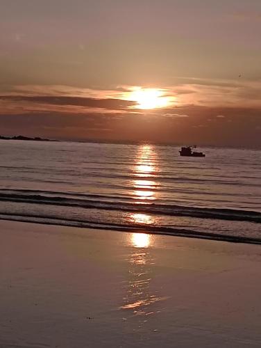 a sunset over the ocean with a boat in the water at hotel manglar in Mompiche