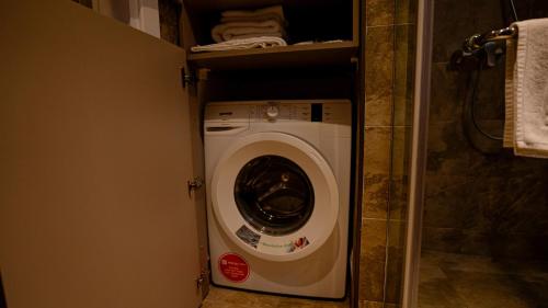 a washer and dryer in a small bathroom at Alliance Palace Seaside in Batumi