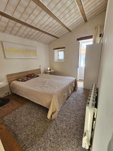 une chambre avec un lit et une grande fenêtre dans l'établissement Maison Rétaise près de la Plage, à Saint-Clément-des-Baleines