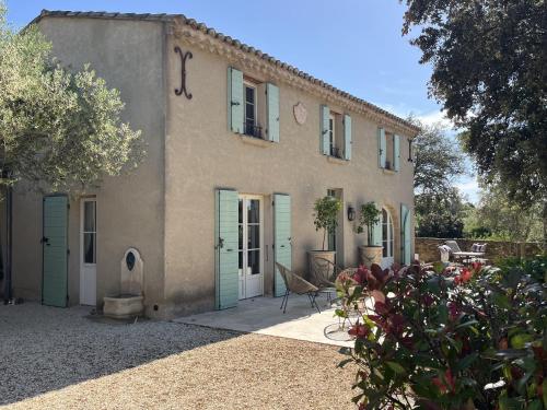 ein großes Haus mit blauen Türen und einem Hof in der Unterkunft Bastide des Oliviers in Castillon-du-Gard