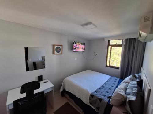 a bedroom with a bed and a desk and a television at Asa Norte - Suíte Premium - Conforto e praticidade in Brasília