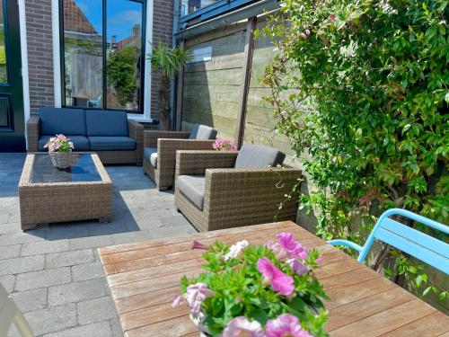 a patio with wicker chairs and a table with flowers at Boutique Hotel Joure - centrum & haven in Joure