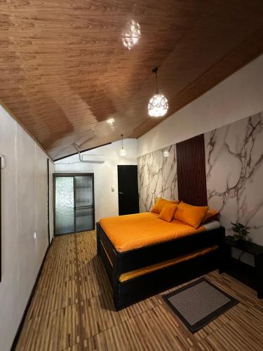 a bedroom with a bed with orange pillows on it at Caribbean View in Tortuguero