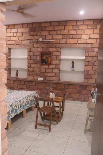 a room with a brick wall and a table and chairs at Mordhwaj in Jodhpur