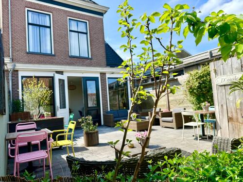 a patio with chairs and a table and a tree at Boutique Hotel Joure - centrum & haven in Joure