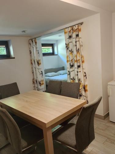 a dining room with a table and chairs and a bedroom at Agro-Relax in Bałtów