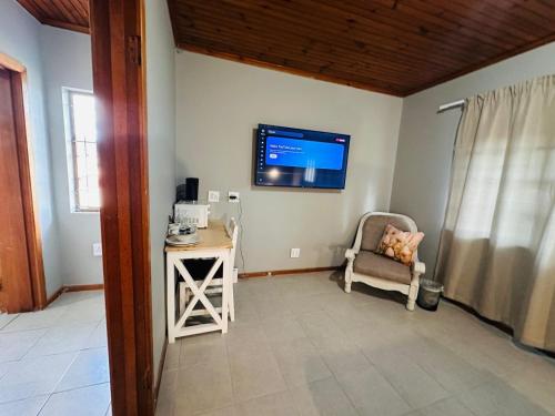 a living room with a chair and a tv on the wall at Aruwaa in East London
