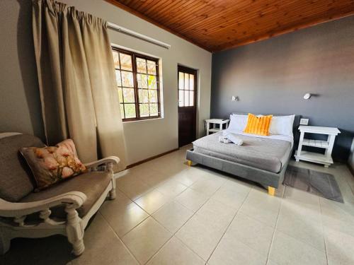 a bedroom with a bed and a chair and a window at Aruwaa in East London