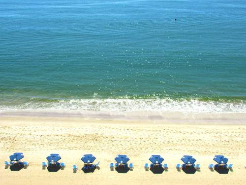 a group of chairs on a beach near the ocean at Rede Andrade Atlântico in Piçarras