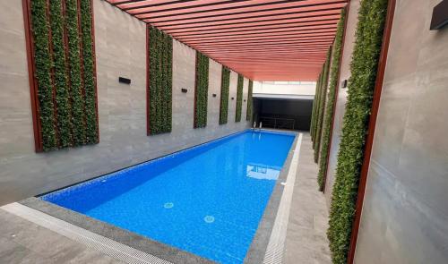 a swimming pool in a building with plants at Modern 3BR 2BA Apt Gym and Parking Near Real Plaza, UP and Trendy Cafés in Lima
