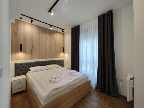 Un dormitorio con una cama grande y una ventana grande en Omorika Lux, en Zlatibor
