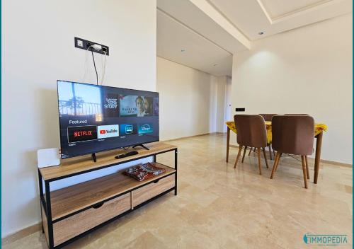 sala de estar con TV de pantalla plana y sillas en Le Refuge Océanique idéal !, en Benslimane