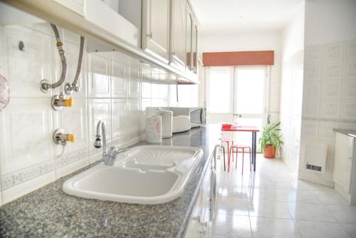 una cocina blanca con fregadero en una habitación en Lagos Bay View Flat, en Lagos