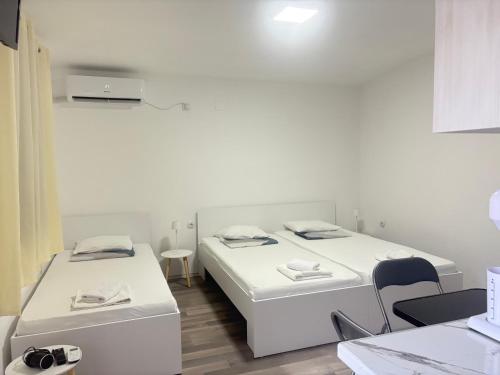 a room with two beds and a table and chairs at TIKI Apartments in Gevgelija
