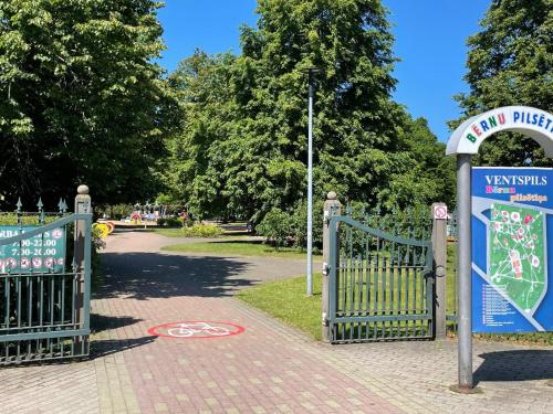 een poort naar een park met een bord erop bij Elena in Ventspils
