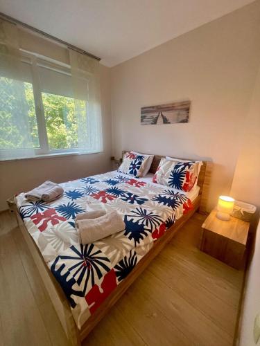 a bedroom with a bed with a colorful comforter at Byla Sea side Apartament in Byala