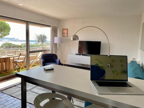 a laptop computer sitting on a table in a living room at Le bleu de George Sand, hébergement de charme à Tamaris in La Seyne-sur-Mer