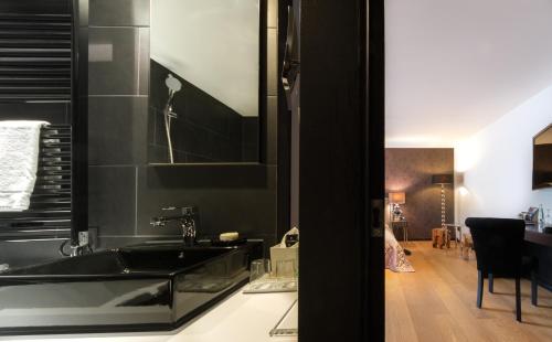 a black kitchen with a sink and a living room at La Mansion Vi Vadi Hotel in Munich