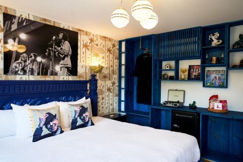 a bedroom with blue walls and a bed with white sheets at Motel Chelsea in Chelsea