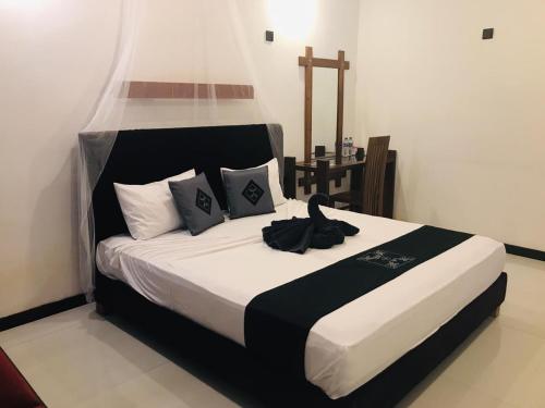 a bedroom with a bed with a black and white comforter at Sigiri Holiday Bungalow in Sigiriya