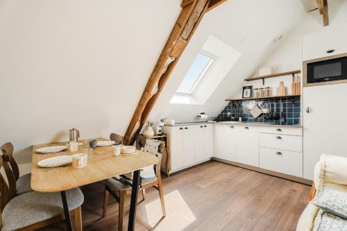 une cuisine avec une table en bois et une salle à manger dans l'établissement La Mer - Appartement calme et douillet à 5km du Mont St Miche - Wifi - Netflix, à Pontorson