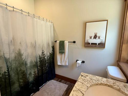 a bathroom with a shower curtain and a sink at 56 Black Bear Bungalow in North Wawona