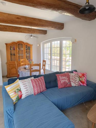 - un canapé bleu avec des oreillers colorés dans le salon dans l'établissement Château de Prax Viel - piscine et mini ferme, climatisé, à Lagrasse