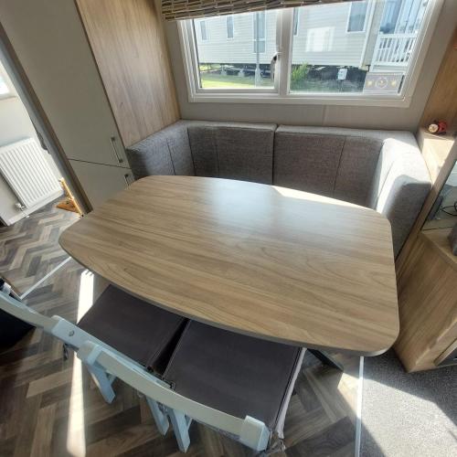 a wooden table with two chairs and a couch at No 22 - Seaview Dream Retreatt in Newbiggin-by-the-Sea
