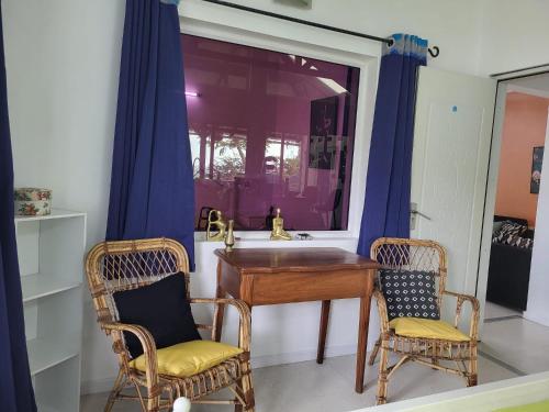 a bathroom with a table and two chairs and a sink at La maison bleue pieds dans l'eau in Petite Verger