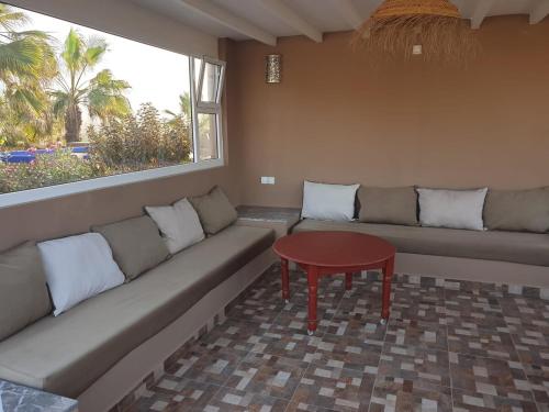 a living room with a couch and a table at Villa bord de mer, piscine, fibre internet, Sidi Boulfdail, Mirleft in Mirleft