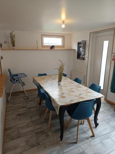 une salle à manger avec une table et des chaises bleues dans l'établissement Maison de campagne avec cour, à Sées