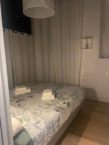 a small bedroom with a bed with a green and white comforter at l atypique d Édouard in Grenoble