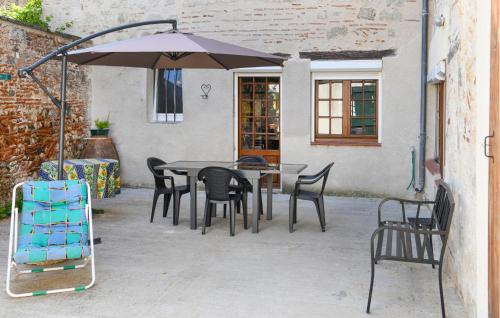 a table and chairs with an umbrella on a patio at 4 Bedroom Cozy Home In Aiguillon in Aiguillon