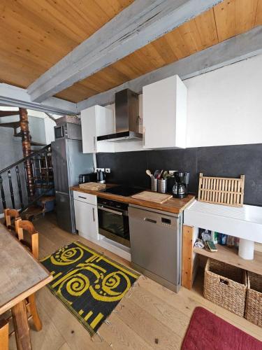 une cuisine avec des armoires blanches et un four à plaques de cuisson dans l'établissement Maison Rétaise près de la Plage, à Saint-Clément-des-Baleines