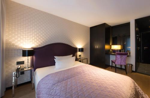 a bedroom with a large bed in a room at La Mansion Vi Vadi Hotel in Munich