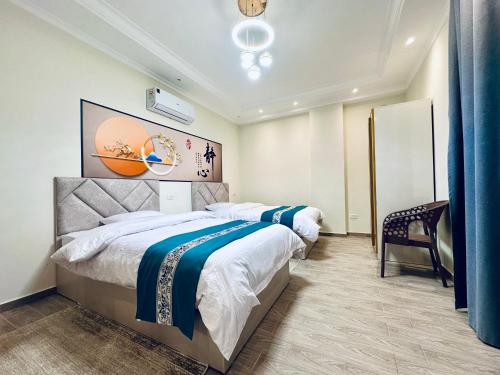 ein Hotelzimmer mit zwei Betten und einem Stuhl in der Unterkunft Vista Mansion in New cairo