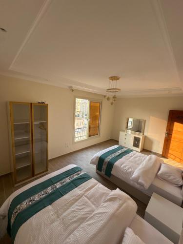 1 Schlafzimmer mit 2 Betten und einem TV in der Unterkunft Vista Mansion in New cairo