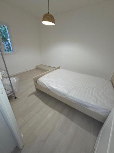 - une chambre blanche avec un lit et une lumière dans l'établissement charmant t2, à Petreto-Bicchisano