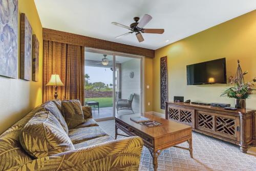 a living room with a couch and a tv at Castle Hali'i Kai at Waikoloa in Waikoloa