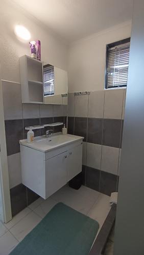 a bathroom with a sink and a mirror at Sun-Moon Apartment in Zbilje