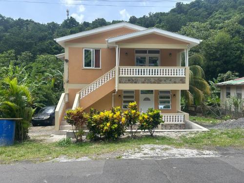 a house with a balcony and flowers in front of it at Rail Apartments in Loubiere