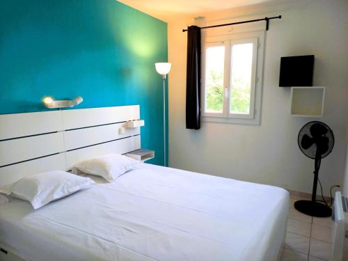 a bedroom with a white bed and a window at Résidence Villa Antoinette - maeva Home - Appartement 3 pièces 4 personnes - Exclusive MAE-6573 in Grimaud